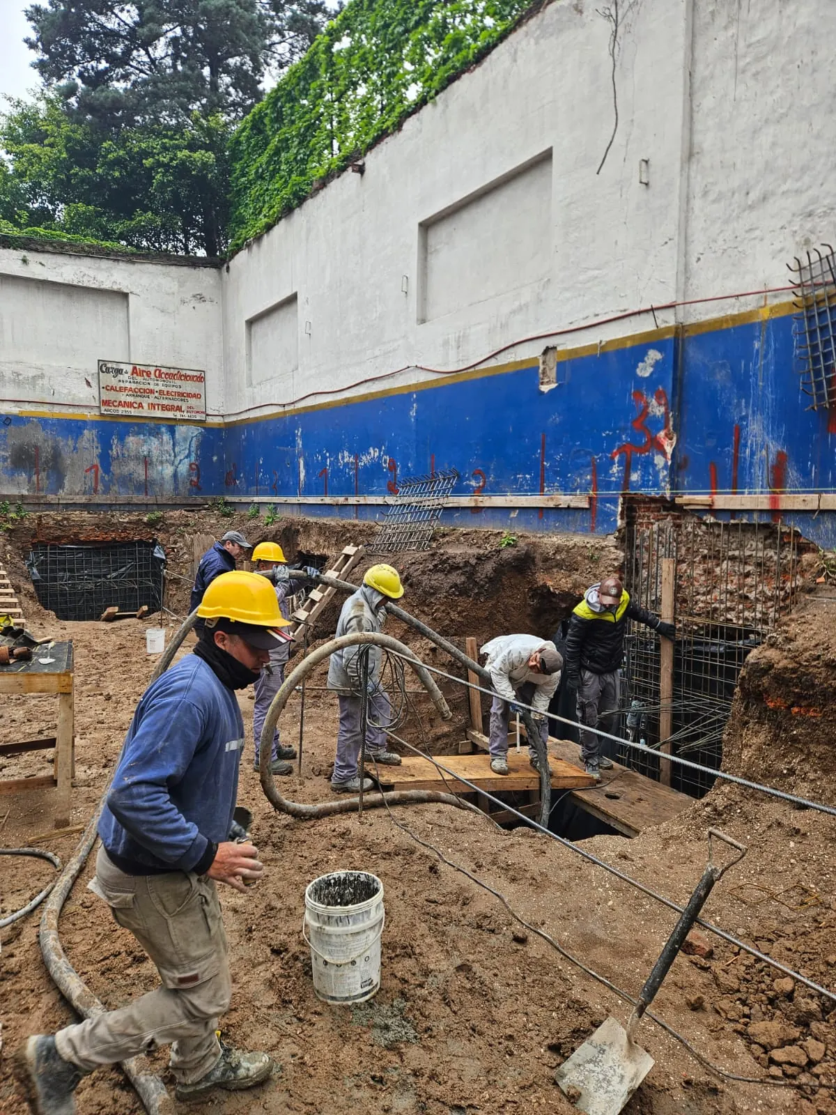 Operarios trabajando en la submuración junto a la medianera